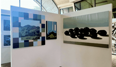 Two paintings hung on a wall at Andaz Costa Rica Resort. One abstract with browns, pinks and blues, the other hyperrealist showing bull's eye seed pods.
